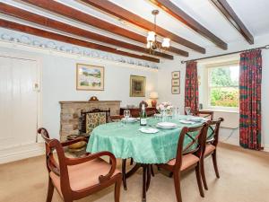 a dining room with a table and chairs and a fireplace at Corner House in Grinton