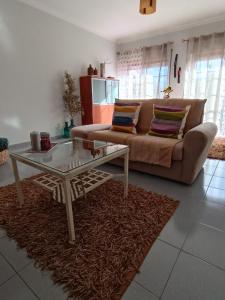 a living room with a couch and a coffee table at GREEN GARDEN APARTMENT IN ODIVELAS in Odivelas