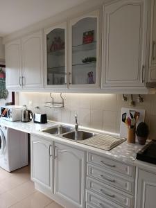 a kitchen with white cabinets and a sink at GREEN GARDEN APARTMENT IN ODIVELAS in Odivelas