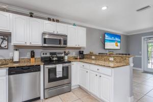 uma cozinha com armários brancos e electrodomésticos de aço inoxidável em Minorga on the Gulf em Siesta Key