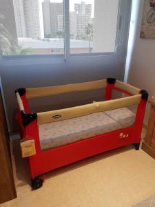 a toddler bed in a room with a window at HR PARADISE PARQUE RESIDENCIAL in Benidorm