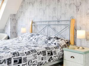 a bedroom with a bed with a black and white comforter at Little Harrowfield in Bankfoot