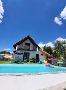 een huis met een zwembad ervoor bij Oaza Mira-vikend kuca sa bazenom in Pale