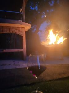 a glass of wine in front of a fire at Oaza Mira-vikend kuca sa bazenom in Pale