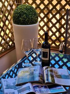 a table with a bottle of wine and two glasses at Suite Carducci Viareggio in Viareggio