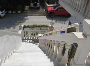 a stairway with a white railing on a house at Aegean Hotel in Agia Triada
