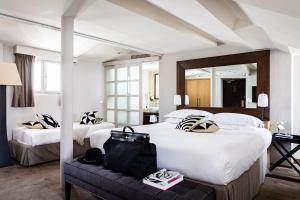 a hotel room with two beds and a mirror at Holiday Inn Paris Palais de l'Elysée in Paris