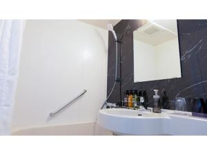 ein Badezimmer mit einem weißen Waschbecken und einem Spiegel in der Unterkunft ＹＯＵ ＳＴＹＬＥ ＨＯＴＥＬ ＨＡＫＡＴＡ - Vacation STAY 16027v in Fukuoka