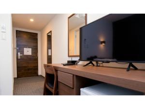 Zimmer mit einem großen Flachbild-TV auf einem Schreibtisch in der Unterkunft ＹＯＵ ＳＴＹＬＥ ＨＯＴＥＬ ＨＡＫＡＴＡ - Vacation STAY 16027v in Fukuoka