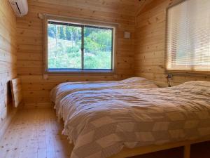 a bedroom with a bed in a log cabin at NEXX IKI - Vacation STAY 16966v in Iki