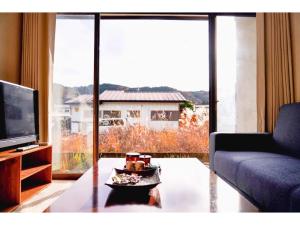 a living room with a couch and a large window at Second House Nikko - Vacation STAY 13408 in Nikko