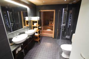 a bathroom with two sinks and a shower at Vuokatinmaa Holiday Apartments in Vuokatti