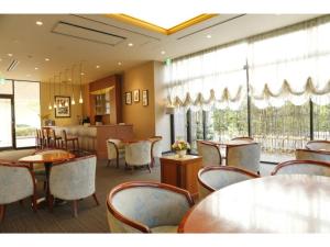 un comedor con mesas, sillas y ventanas en Ako onsen AKO PARK HOTEL - Vacation STAY 21678v, en Ako