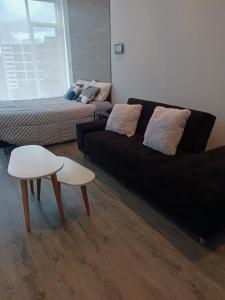 ein Wohnzimmer mit einem schwarzen Sofa und einem Bett in der Unterkunft Loft Moderno en Bogotá -Usaquén in Bogotá