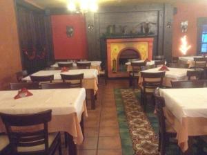 a restaurant with white tables and a fire place at Astrovolia in Pertouli