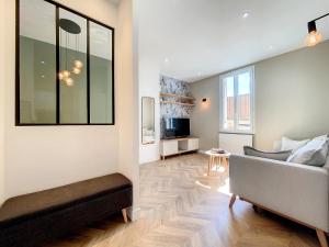 a living room with a couch and a television at AppartChic - appartement standing - plein Centre & Parking privé in Créon