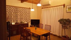 une salle à manger avec une table, des chaises et une télévision dans l'établissement Guest House Nishimura - Vacation STAY 13436, à Kyoto