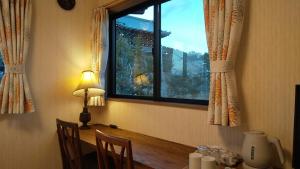 a room with a table with a window and a lamp at Guest House Nishimura - Vacation STAY 13436 in Kyoto