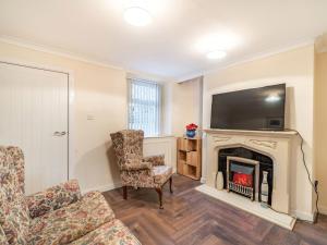 sala de estar con chimenea y TV en Yantethera en Arlecdon