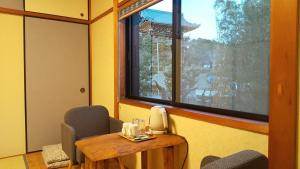 een kamer met een tafel en stoelen en een raam bij Guest House Nishimura - Vacation STAY 13438 in Kyoto