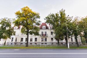 a white building with trees in front of a street at Samson Hotel in Petergof