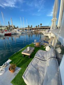 un patio en un barco con una mesa y barcos en el agua en The Floating Home en Barcelona