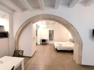 an archway in a room with a bed and a table at Corinzia Casa Vacanze in Siracusa