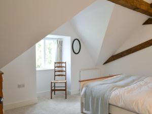 a bedroom with a bed and a ladder next to a window at Printmakers Cottage in Bellanoch