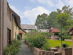 einen Garten mit einem Weg, der zu einem Haus führt in der Unterkunft Brookside Cottage in Adforton