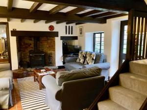 a living room with two couches and a fireplace at Brookside Cottage in Adforton