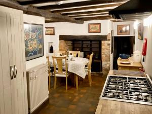 uma cozinha e sala de jantar com mesa e cadeiras em Brookside Cottage em Adforton