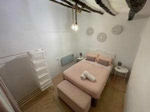 a small bedroom with a bed and a stool at Casa Rural Villa Leire en pleno corazón del Valle Ricote in Blanca