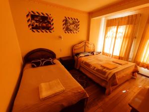 科帕卡巴納的住宿－Hostal Las Balsas，一间卧室设有两张床和窗户。