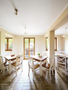 a dining room with tables and chairs and windows at Willa Alicja in Ustroń