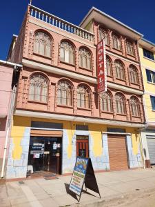 科帕卡巴納的住宿－Hostal Las Balsas，前面有标志的建筑