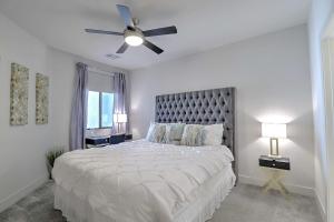 a white bedroom with a large bed with a ceiling fan at Exquisite Home-Walk Score 81-Shopping District-King Bed-Parking -G3021 in Scottsdale