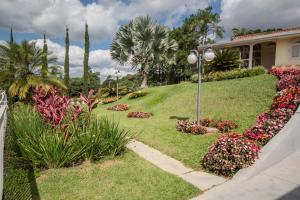 a house with flowers in front of a yard at Pousada Vegas in São Roque