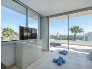 sala de estar con TV y 2 zapatillas azules en Magnifique villa contemporaine, en Marbella