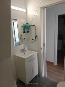 a white bathroom with a sink and a mirror at A casiña de Vilaxoan in Vilagarcia de Arousa