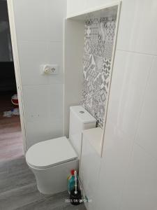 a white bathroom with a toilet in a room at A casiña de Vilaxoan in Vilagarcia de Arousa