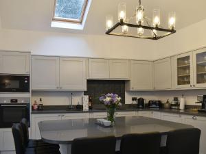 a kitchen with a table with a vase of flowers on it at The Cottage in Bewdley