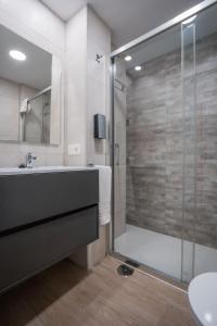 a bathroom with a shower and a tub and a sink at QH Avenida de la Constitución in Granada