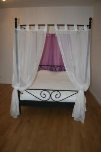 プラハにあるApartment Marilynの小さなベッド(天蓋、白いカーテン付)