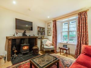 a living room with a fireplace and a tv at Barjols Cottage - Uk30096 in Wiston