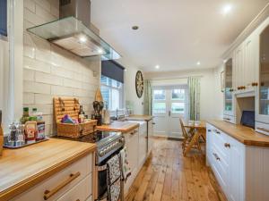a kitchen with white cabinets and a stove top oven at Barjols Cottage - Uk30096 in Wiston