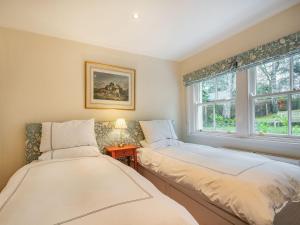 two beds in a room with a window at Barjols Cottage - Uk30096 in Wiston