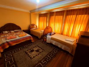 a small room with two beds and a rug at Hostal Las Balsas in Copacabana