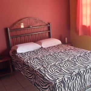 a bed with a black and white comforter in a bedroom at Pousada Moinho De Vento in Bonito