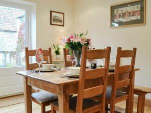 a dining room table with a vase of flowers on it at Bondgate in Helmsley