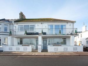 a white house with a balcony on a street at Herons Haven - Uk31452 in Paignton